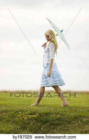Young woman holding an umbrella View Large Photo Image Stock Photography - Young woman holding an umbrella. Fotosearch