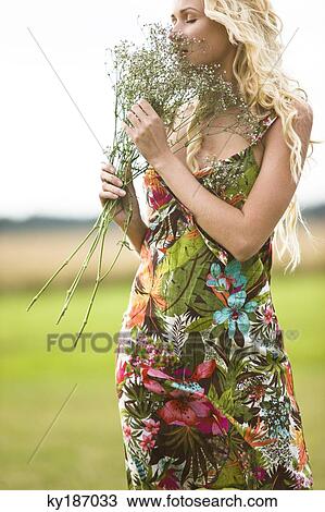 Young woman holding bunch of flowers View Large Photo Image Stock Image - Young woman holding bunch of flowers. Fotosearch