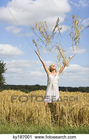 Stock Image - Young woman in a wheat field. Fotosearch