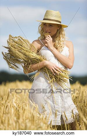 Stock Image - Young woman in a wheat field. Fotosearch
