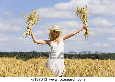 Young woman in a wheat field View Large Photo Image Stock Image - Young woman in a wheat field. Fotosearch