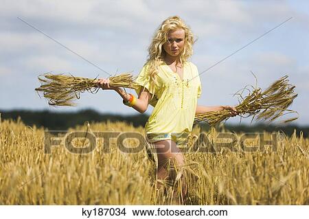Picture - Young woman in wheat field. Fotosearch