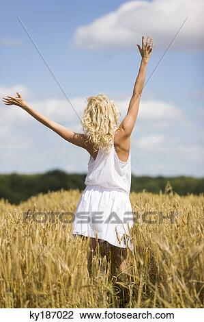 Young woman in wheat field View Large Photo Image Stock Image - Young woman in wheat field. Fotosearch