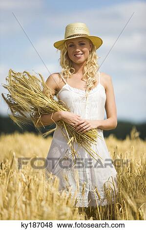 Young woman in wheat field View Large Photo Image Stock Photo - Young woman in wheat field. Fotosearch