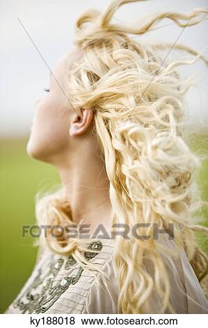 Stock Photo - Portrait of a young woman, hair in the wind. Fotosearch