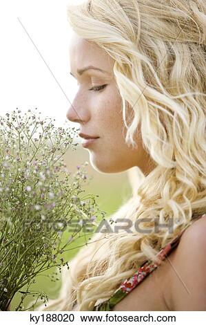 Portrait of a young woman holding a bunch of flowers View Large Photo Image Stock Image - Portrait of a young woman holding a bunch of flowers. Fotosearch