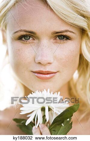 Portrait of a young woman holding a white flower View Large Photo Image Stock Image - Portrait of a young woman holding a white flower. Fotosearch
