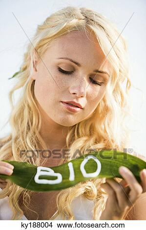 Young woman hlding a leaf with "BIO" lettering View Large Photo Image Picture - Young woman hlding a leaf with "BIO" lettering. Fotosearch