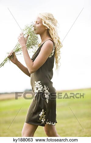 Young woman holding a bunch of flowers View Large Photo Image Stock Image - Young woman holding a bunch of flowers. Fotosearch