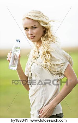Young woman holding a water bottle View Large Photo Image Stock Image - Young woman holding a water bottle. Fotosearch