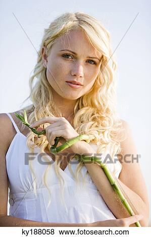 Young woman holding bamboo View Large Photo Image Stock Photo - Young woman holding bamboo. Fotosearch