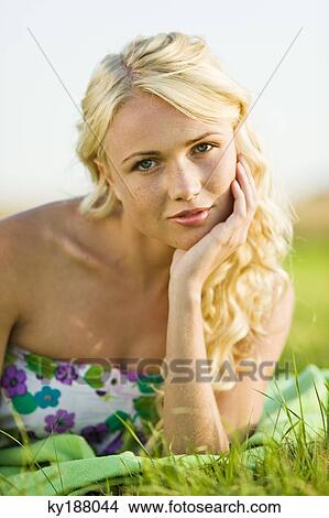 Young woman lying in grass View Large Photo Image Picture - Young woman lying in grass. Fotosearch