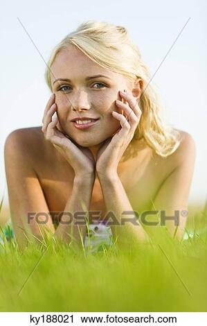 Young woman lying in grass View Large Photo Image Stock Image - Young woman lying in grass. Fotosearch