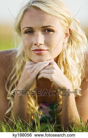 Stock Photograph - Young woman lying in grass. Fotosearch