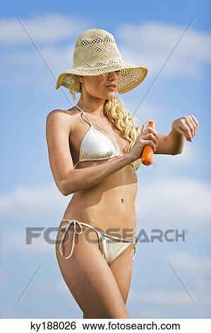 Young woman spraying suncream on her arm View Large Photo Image Stock Photograph - Young woman spraying suncream on her arm. Fotosearch