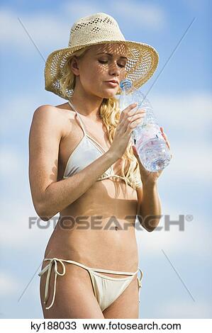 Young woman wearing a bathsuit, holding a water bottle View Large Photo Image Stock Image - Young woman wearing a bathsuit, holding a water bottle. Fotosearch