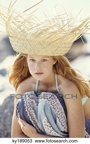 Stock Image - Portrait of a young woman outdoors, sunhat. Fotosearch