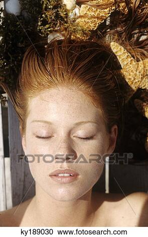 Young woman lying outdoors, sunbathing View Large Photo Image Stock Image - Young woman lying outdoors, sunbathing. Fotosearch