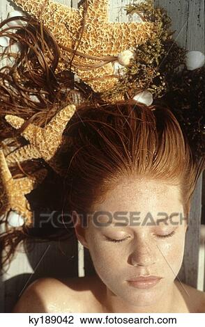 Young woman lying outdoors, sunbathing View Large Photo Image Stock Image - Young woman lying outdoors, sunbathing. Fotosearch