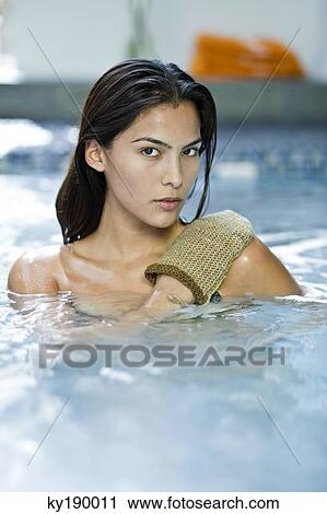 Portrait of a woman using an exfoliation glove View Large Photo Image Stock Image - Portrait of a woman using an exfoliation glove. Fotosearch