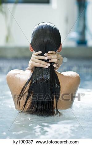 Rear view of a woman in a swimming pool View Large Photo Image Stock Photo - Rear view of a woman in a swimming pool. Fotosearch