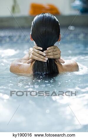 Rear view of a woman in a swimming pool View Large Photo Image Stock Photograph - Rear view of a woman in a swimming pool. Fotosearch