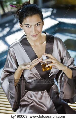 Woman holding a bottle of aromatherapy oil View Large Photo Image Stock Image - Woman holding a bottle of aromatherapy oil. Fotosearch