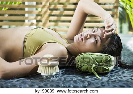Woman lying at the poolside View Large Photo Image Stock Photo - Woman lying at the poolside. Fotosearch
