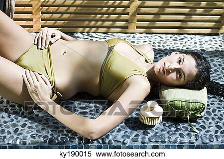 Woman lying at the poolside View Large Photo Image Stock Photography - Woman lying at the poolside. Fotosearch