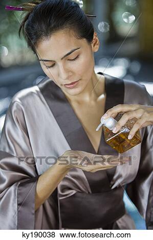 Woman pouring oil on her hand from a dispenser View Large Photo Image Stock Photo - Woman pouring oil on her hand from a dispenser. Fotosearch