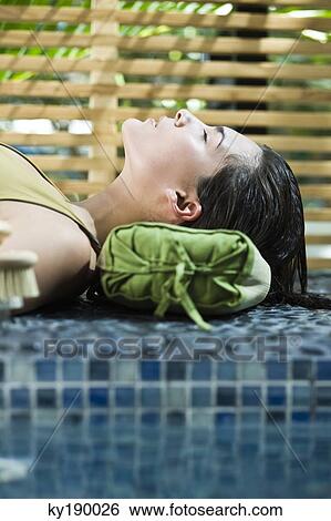 Woman resting at the poolside View Large Photo Image Stock Photograph - Woman resting at the poolside. Fotosearch