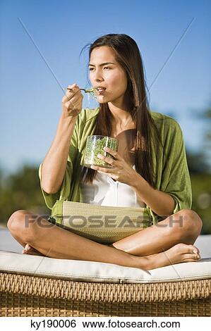 Woman sitting on a mattress and eating bean sprouts View Large Photo Image Stock Photograph - Woman sitting on a mattress and eating bean sprouts. Fotosearch