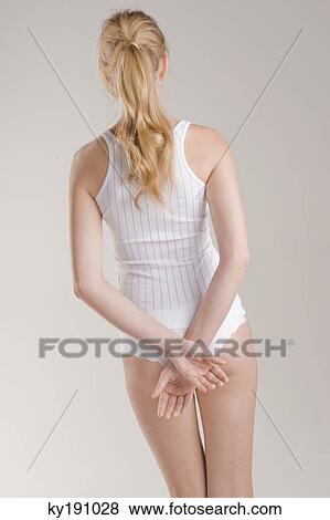 Rear view of a woman standing with her hands behind her back View Large Photo Image Stock Photo - Rear view of a woman standing with her hands behind her back. Fotosearch