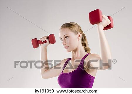 Woman exercising with dumbbells View Large Photo Image Stock Image - Woman exercising with dumbbells. Fotosearch
