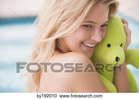 Close-up of a woman holding a teddy bear and smiling View Large Photo Image Stock Image - Close-up of a woman holding a teddy bear and smiling. Fotosearch