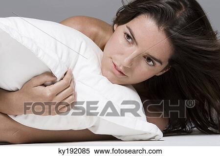 Close-up of a woman hugging a pillow View Large Photo Image Stock Photography - Close-up of a woman hugging a pillow. Fotosearch