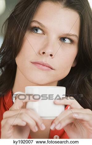 Woman holding a cup of tea and thinking View Large Photo Image Stock Photo - Woman holding a cup of tea and thinking. Fotosearch
