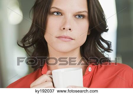 Woman holding a cup of tea and thinking View Large Photo Image Stock Photo - Woman holding a cup of tea and thinking. Fotosearch