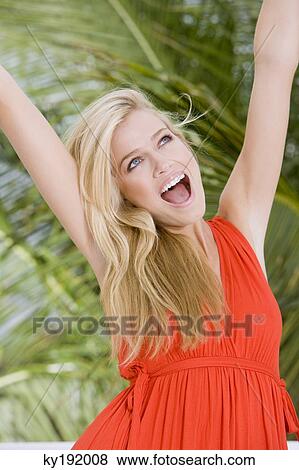 Woman laughing with her arms raised View Large Photo Image Stock Photo - Woman laughing with her arms raised. Fotosearch