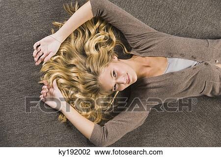 Woman lying on a round sofa and smiling View Large Photo Image Stock Image - Woman lying on a round sofa and smiling. Fotosearch