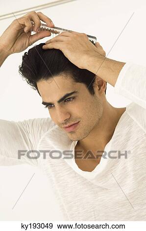 Close-up of a man combing his hair View Large Photo Image Stock Photo - Close-up of a man combing his hair. Fotosearch