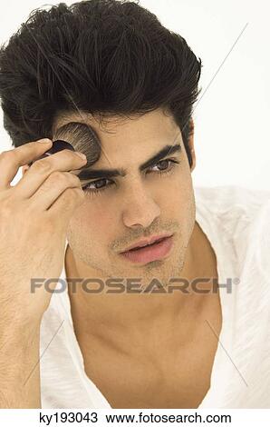 Man applying blush on his face View Large Photo Image Stock Image - Man applying blush on his face. Fotosearch