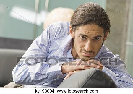 Man leaning on a couch View Large Photo Image Picture - Man leaning on a couch. Fotosearch