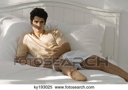 Man lying on the bed View Large Photo Image Stock Photography - Man lying on the bed. Fotosearch