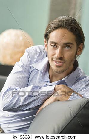 Man sitting on a couch View Large Photo Image Stock Image - Man sitting on a couch. Fotosearch