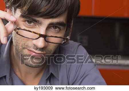 Portrait of a man adjusting eyeglasses View Large Photo Image Stock Photo - Portrait of a man adjusting eyeglasses. Fotosearch