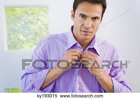 Portrait of a man buttoning shirt View Large Photo Image Stock Photography - Portrait of a man buttoning shirt. Fotosearch