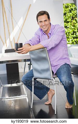 Portrait of a man holding a coffee cup and smiling View Large Photo Image Stock Photo - Portrait of a man holding a coffee cup and smiling. Fotosearch