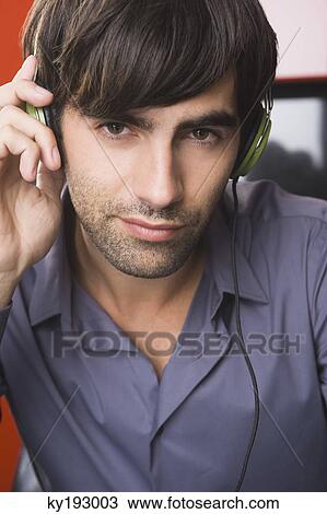 Portrait of a man listening to headphones View Large Photo Image Stock Image - Portrait of a man listening to headphones. Fotosearch