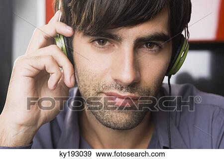Portrait of a man listening to headphones View Large Photo Image Stock Photo - Portrait of a man listening to headphones. Fotosearch